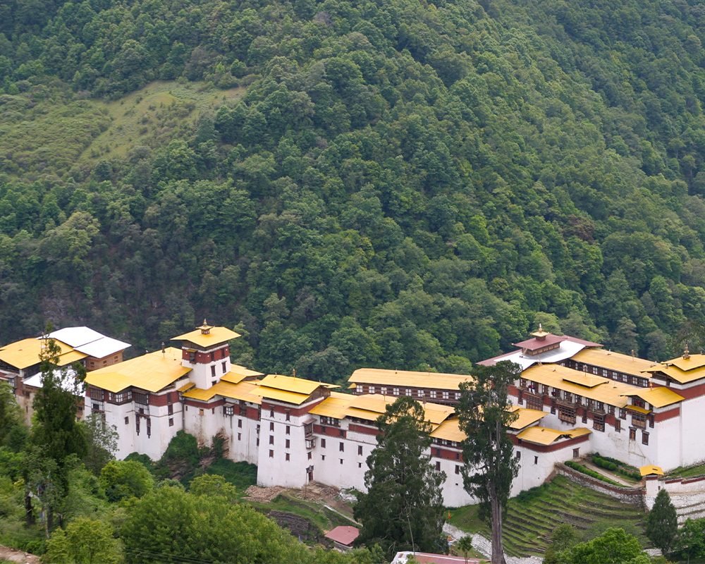 Trongsa Dzong with golden roofs set against forested hills in central Bhutan